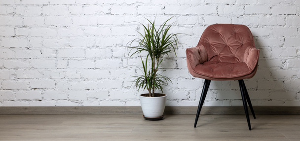 cadeira rosa e vaso de flores no fundo da parede de tijolo branco. design de interiores minimalismo. espaço de cópia banner - Foto, Imagem