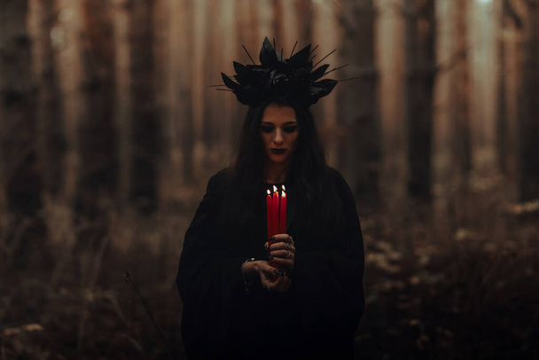 black terrible witch holds candles in her hands - 写真・画像