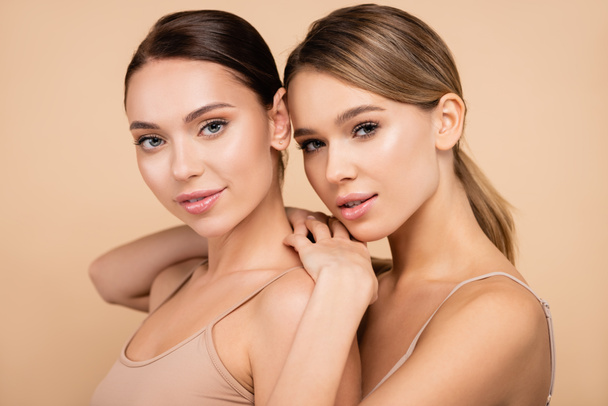 two young women with natural makeup posing isolated on beige - Foto, Imagen