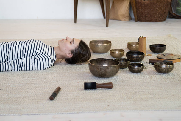 Woman practice meditation with tibetan singing bowls therapy: female meditating from sound massage - Photo, Image