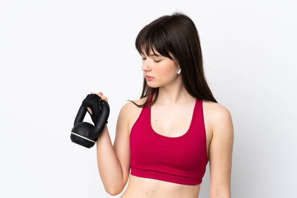 Junge Sportlerin isoliert auf weißem Hintergrund macht Gewichtheben mit Kettlebell - Foto, Bild