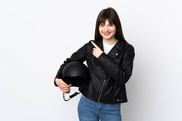 Женщина с мотоциклетным шлемом на белом фоне указывает пальцем в сторону - Фото, изображение