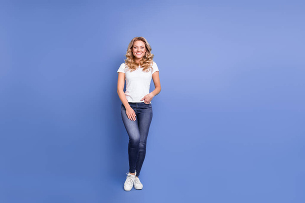 Ganzkörpergröße Ansicht der attraktiven fröhlichen welligen Mädchen tragen gemütliche Kleidung isoliert über blauer Farbe Hintergrund - Foto, Bild
