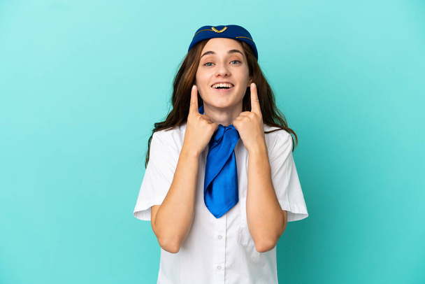Azafata de avión mujer aislada sobre fondo azul sonriendo con una expresión feliz y agradable - Foto, Imagen