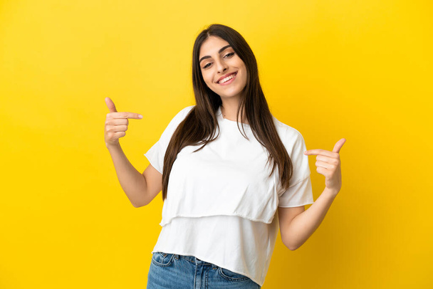 Young caucasian woman isolated on yellow background proud and self-satisfied - Photo, Image