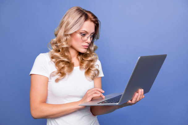 Portrait de fille aux cheveux ondulés attrayant rédacteur à l'aide d'un ordinateur portable écriture e-mail isolé sur fond de couleur bleue - Photo, image