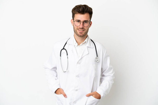 Fiatal orvos kaukázusi férfi felett elszigetelt fehér háttér visel orvosi köpeny és sztetoszkóppal - Fotó, kép