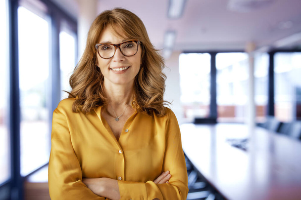 Shot of smiling mature businesswoman standing in the meeting room at the office.  - Fotoğraf, Görsel