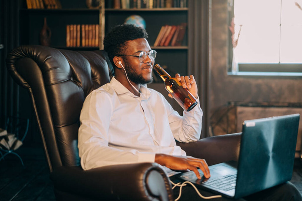 young attractive and happy successful black African American man networking with laptop computer at living room armchair - Foto, Imagem