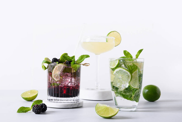 Classic and blackberry mojito, margarita cocktail with lime on modern color background. Three summer freshness beverage for festive party. Summer holiday mocktail. - Fotó, kép