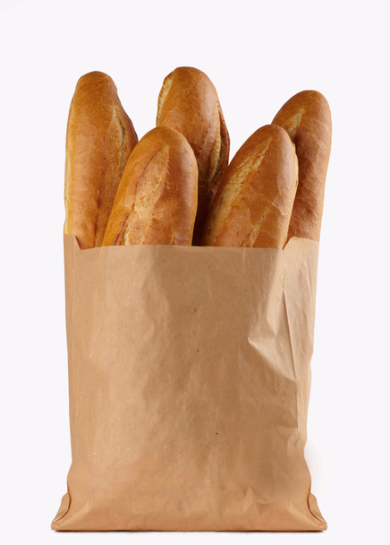 Άχυρο λευκού ψωμιού, συσκευασμένο σε χάρτινη σακούλα σε λευκό φόντο - Φωτογραφία, εικόνα