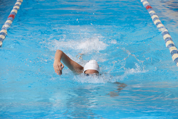 женщина в купальнике, купающаяся в голубом бассейне - Фото, изображение
