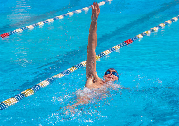 an adult, former swimmer, trains in a public swimming pool, with sun - Фото, зображення