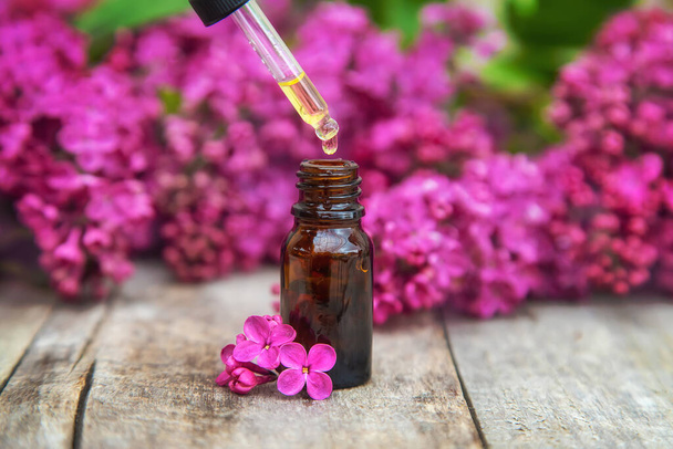 Lilac essential oil in a small bottle. Selective focus. Nature. - Photo, Image