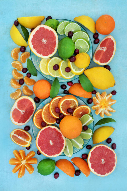Agrumi sani per un elevato apporto di fibre con arance, limoni, lime e pompelmi anche ricchi di antiossidanti, antociani e vitamina c. Sistema immunitario che migliora il concetto di assistenza sanitaria. Su chiazzato blu. - Foto, immagini