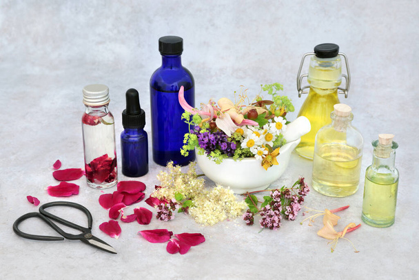 Yaz bitkisi ve çiçek seçimi aromaterapi için gerekli yağları hazırlamak için yağ şişeleri ve yapraklı ve gevşek bir havanda çiçekler. Bitkisel bitki sağlığı sağlık konsepti. - Fotoğraf, Görsel