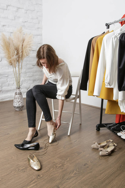 Jonge trendy vrouw kiezen en proberen verschillende syle van schoenen. - Foto, afbeelding