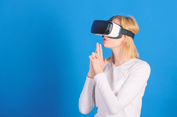 Woman excited using 3d goggles. Young woman using a virtual reality headset. Amazed young woman touching the air during the VR experience. VR image. - Foto, afbeelding