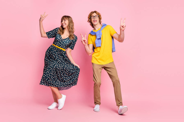 Full length body size view of nice cheerful couple dancing having fun showing v-sign isolated over pink pastel color background - Fotografie, Obrázek