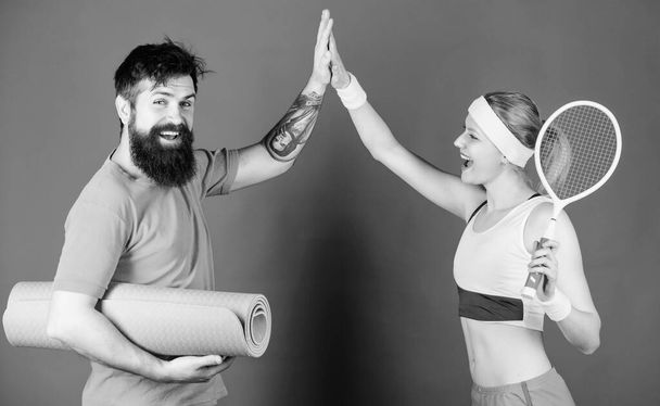 celebrate success. Strong muscles and body. Happy woman and bearded man workout in gym. Athletic Success. Sport equipment. Sporty couple training with fitness mat and tennis racket. success in sport - Foto, Bild