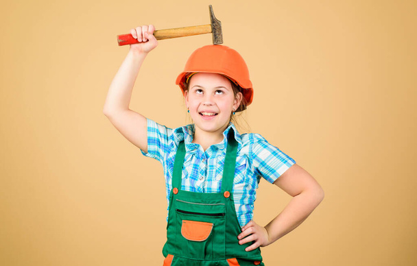 Little girl in helmet with hammer. Kid worker in hard hat. Labor day. 1 may. small girl repairing in workshop. Foreman inspector. Repair. Safety expert. Future profession. feeling cheerful and happy - Photo, Image