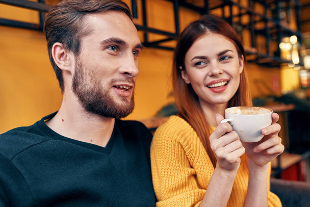 portrait of a man in a sweater and a woman with a cup of coffee interior room - Фото, изображение