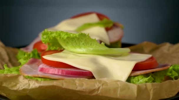 Finom szendvicsek forognak a sötét kő háttér, lapos kilátás. - Felvétel, videó