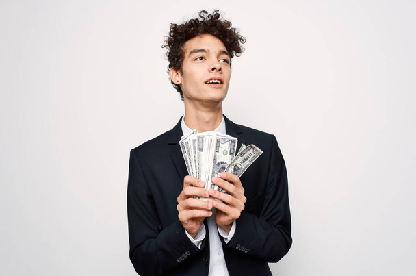 Cheerful man in a suit with money in the hands of a finance official - Foto, afbeelding