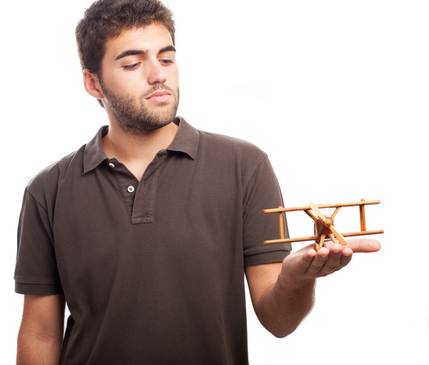 Hombre jugando con avión de madera
 - Foto, imagen