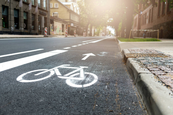 Şehirde yeni inşa edilmiş bisiklet yolu, bisiklet yolu. Kaldırımdaki beyaz boyayı imzala. Yaz. Asfaltta bisiklet trafik tabelası var. - Fotoğraf, Görsel