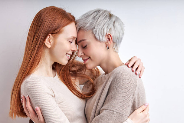 Side view on cool generation z women lgbtq lesbian couple dating, hugging - Fotó, kép