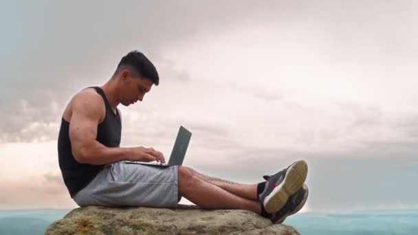 Atletische mannelijke freelancer Werken op laptop en genieten van succes Prachtige omgeving - Video