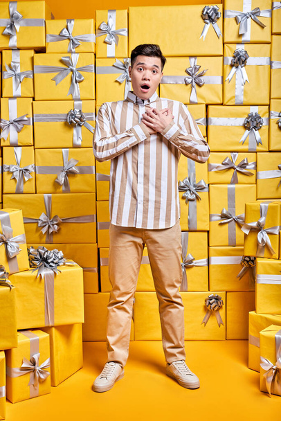 Young Chinese Guy In Casual Shirt Is Surprised By Getting Many Gifts For Birthday - Fotografie, Obrázek