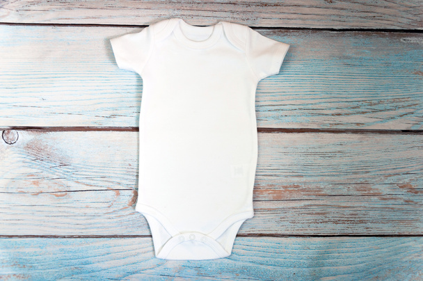 Weiße Baby-Body-Attrappe auf hölzernem Hintergrund. Styled stock photography. Attrappe. - Foto, Bild