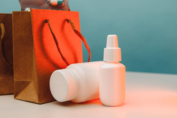 Tema de compras en línea. Bolsas de papel con envases médicos blancos y pastillas de primer plano - Foto, imagen
