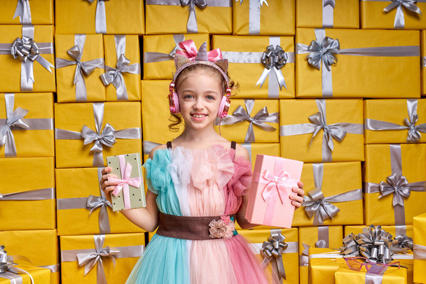 beautiful positive happy little female child wearing party dress holding gift box and having fun - Foto, Bild
