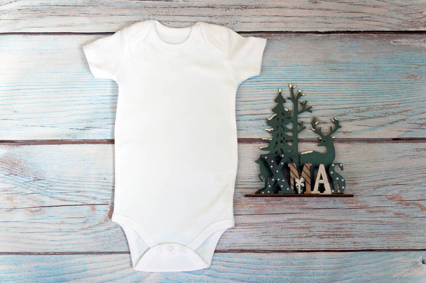 Modèle de costume de bébé blanc sur fond en bois. Photographie de stock stylisée. Maquette - Photo, image