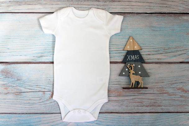 Christmas White baby bodysuit mockup on wooden background. Styled stock photography. Mock up. - Photo, Image