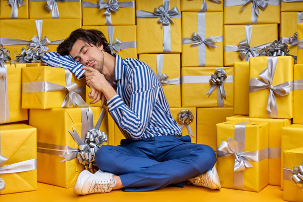 Young Male Entrepreneur Is Sleeping After Hard Working Day, On Floor In Room Full Of Present Boxes - Foto, Imagem