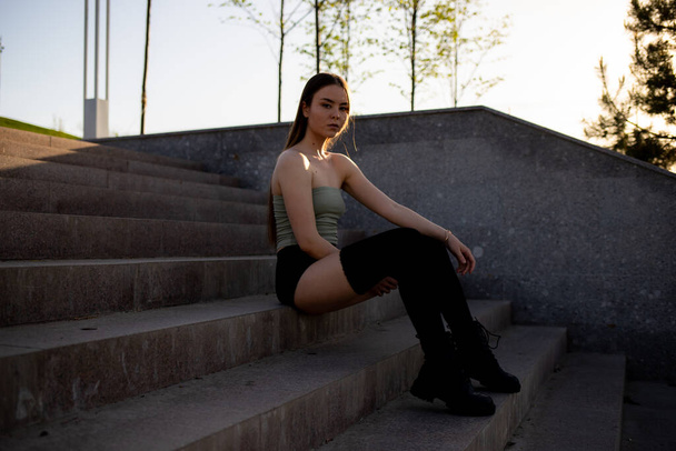 Street photography. Girl on the steps in leggings. - Foto, imagen
