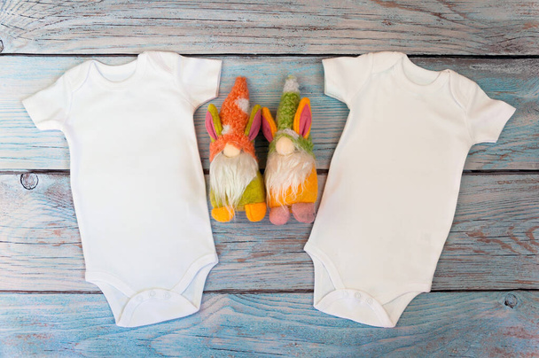 Layout Flat Put on a two white baby bodysuit on a wooden background with gnomes toys. Layout for design and placement of logos, advertising. Styled stock photography, stock photo. flat lay. - Photo, Image