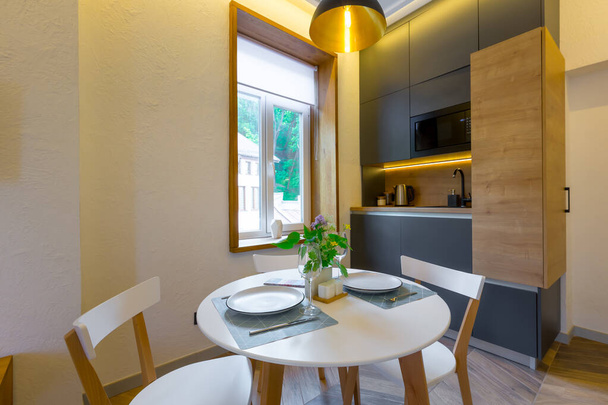 Innenaufnahmen, Loft-Stil, kleine Wohnung mit warmem Licht und dunkler Küche - Foto, Bild