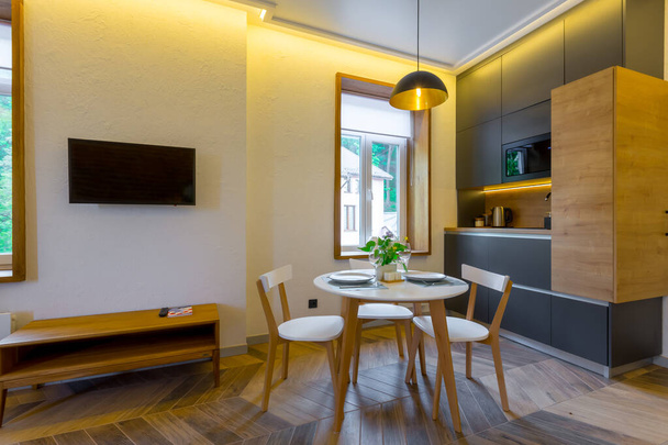 Interior photography, loft style, small apartment with warm light and dark kitchen - Foto, Bild