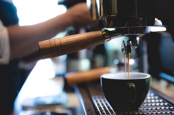 machine à café expresso dans un café, barista professionnel faisant une caféine boisson chaude avec une tasse sur le bar dans un magasin ou un restaurant, café moderne, cafetière cappuccino brun - Photo, image