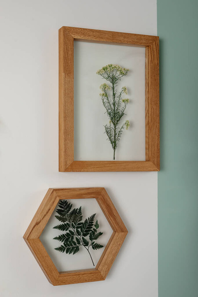 Dry flowers in a frame. walls with botanical leaves. Eco-friendly boho decor. - Foto, Imagem
