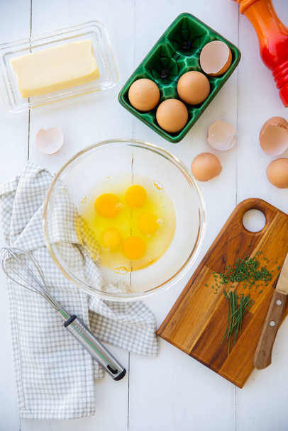 Promesa en lugar de una tortilla. Con huevos en un vaso de bouwl og, huevos, mantequilla, queso parmesano y cebollino - Foto, Imagen