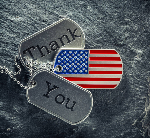Οι στρατιωτικές ταυτότητες των Αμερικανών στρατιωτών είναι χαραγμένες με ευχαριστήριο κείμενο και σε σχήμα Αμερικάνικης σημαίας. Ημέρα Μνήμης ή έννοια Ημέρα Βετεράνων. - Φωτογραφία, εικόνα