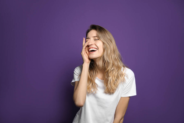 Cheerful young woman laughing on violet background - Fotografie, Obrázek