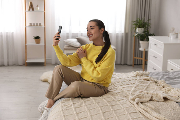 Young woman taking selfie at home in morning - Foto, Bild