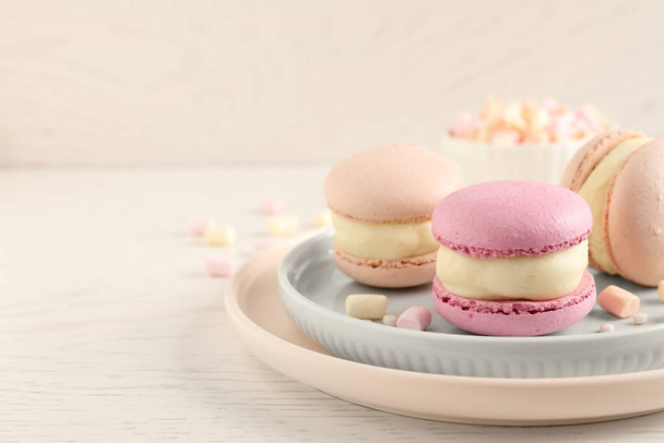 Delicious colorful macarons and marshmallows on white wooden table, closeup. Space for text - Photo, Image